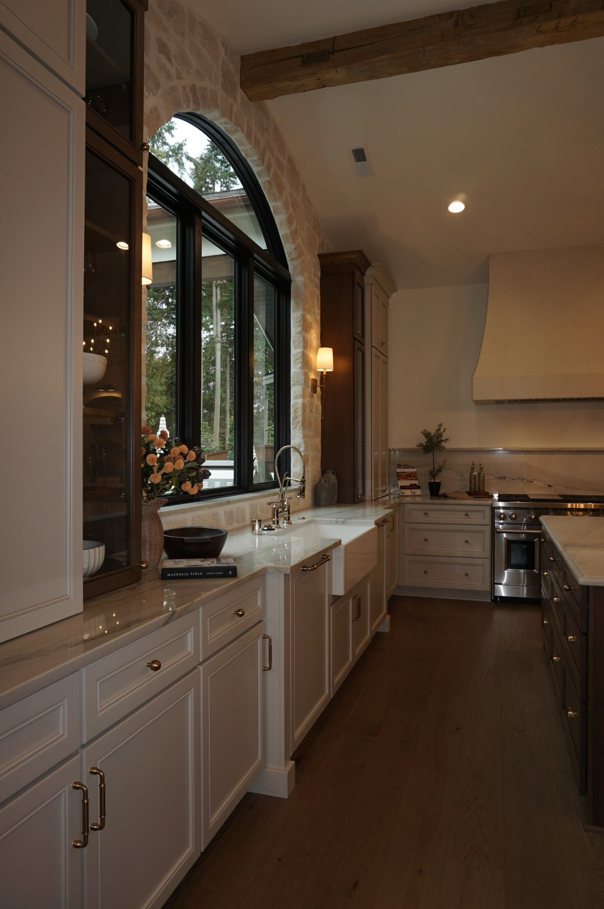 Warm, light-filled kitchen with an arched window and stone accents